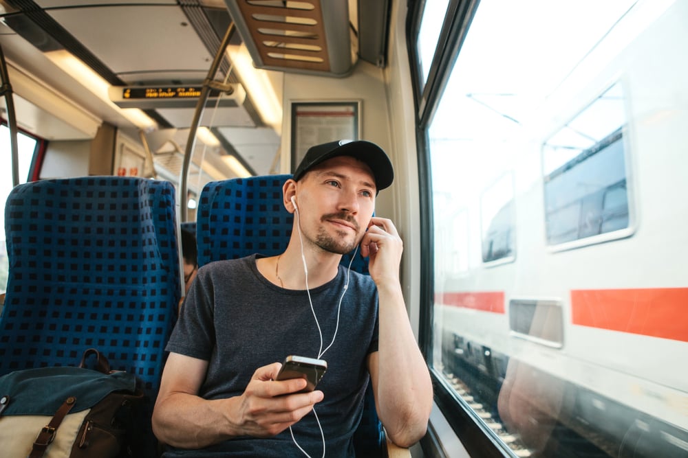 man-listening-to-podcast-on-train-traveling